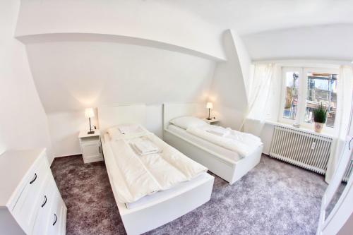 een witte kamer met 2 bedden en een raam bij Fewo Stadtbucht in Eutin