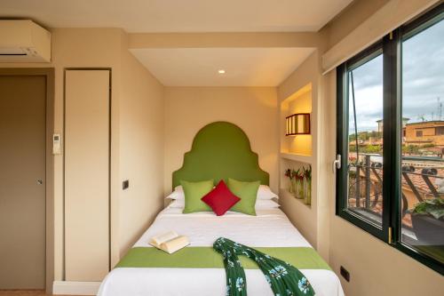 een slaapkamer met een bed met een groen hoofdeinde bij Nido del Gambero - Your Suite with View in Rome