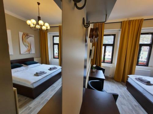 a hotel room with two beds and a mirror at Penzion Pinocchio in Teplice