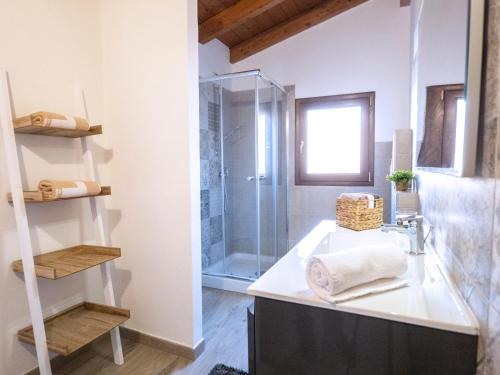 a bathroom with a sink and a glass shower at Casa Canelles (Cod. IUN Q2470) in Iglesias