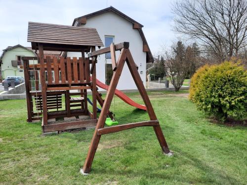 a playground with a slide and a swing set at Megálló Wellness Panzió in Pálháza