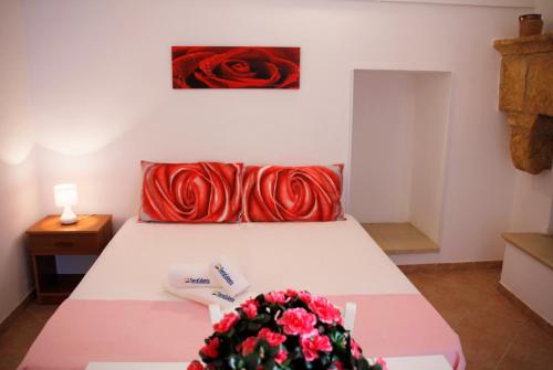 ein Schlafzimmer mit einem Bett mit roten Kissen in der Unterkunft Complesso Giuliano by TerraSalento in Giuliano