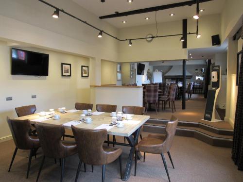 a large dining room with a table and chairs at The Rutland Arms Hotel, Bakewell, Derbyshire - The Coaching Inn Group in Bakewell