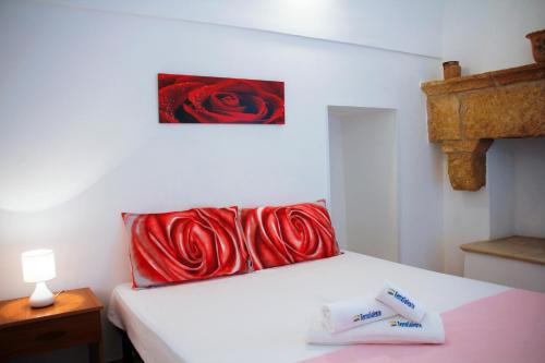 ein Schlafzimmer mit einem Bett mit roten Kissen in der Unterkunft Complesso Giuliano by TerraSalento in Giuliano