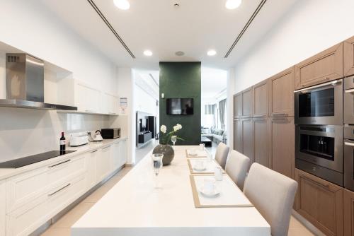 a kitchen with a long white table and chairs at Seafront Villa Cecelia by Ruidoso Luxury in Ayia Napa