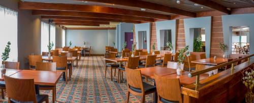 a dining room with wooden tables and chairs at GreenStar Hotel Lahti in Lahti