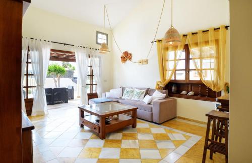 ein Wohnzimmer mit einem Sofa und einem Tisch in der Unterkunft Casa La Goleta, Volcán y Mar in Playa Blanca
