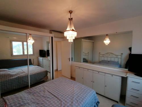 - une chambre avec 2 lits, un miroir et des lustres dans l'établissement Nice Vue Mer 50m plage Parking, à Nice