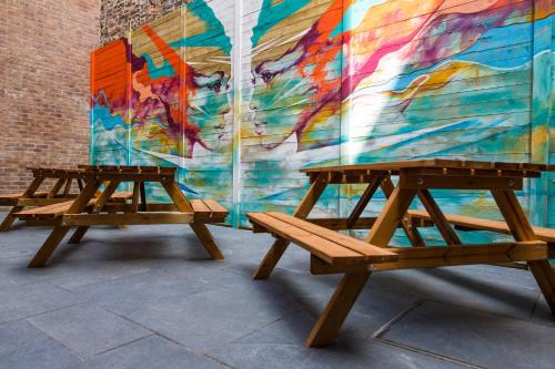 two wooden benches in front of a mural at Duke Street Boutique Hotel in Liverpool