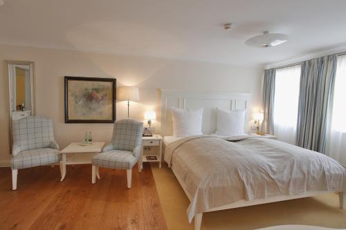 1 dormitorio con 1 cama grande y 2 sillas en Hotel-Restaurant Anne-Sophie, en Künzelsau