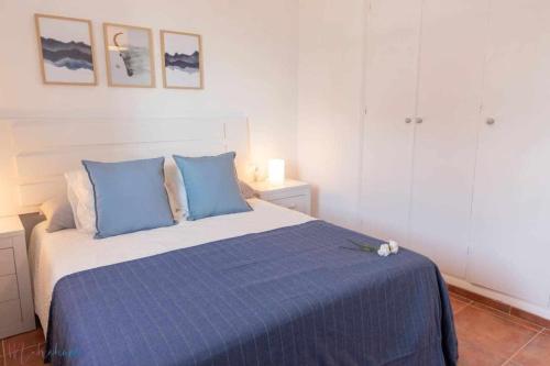 a bedroom with a bed with blue pillows at Apartamento nuevo junto a la playa vistas al mar in Punta Umbría