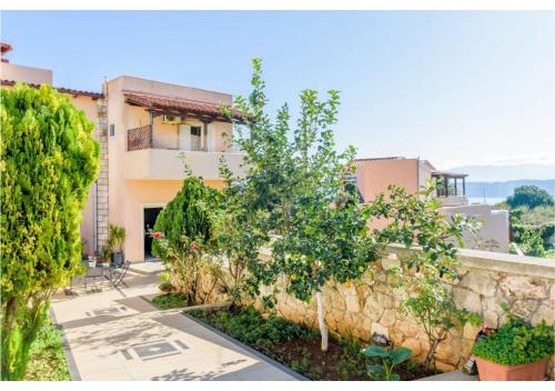 a house with a stone wall and a tree at Andronikis House in Pithárion