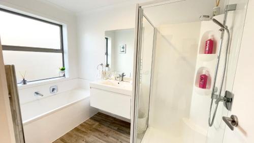 a white bathroom with a sink and a shower at Modern Living in Queenstown