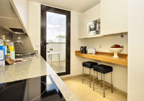 een keuken met 2 barkrukken en een wastafel bij La Casa de Lela in Arrecife