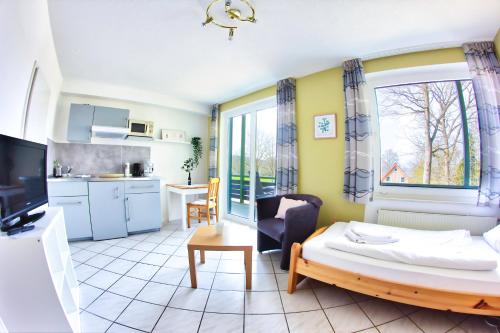a living room with a bed and a kitchen at Pension zur Post in Eutin