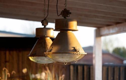 two lights are hanging from a porch at Hip huisje aan de Maas in Lith