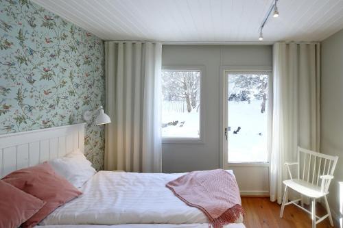 sypialnia z łóżkiem, krzesłem i oknem w obiekcie Arkösunds Hotell w mieście Arkösund