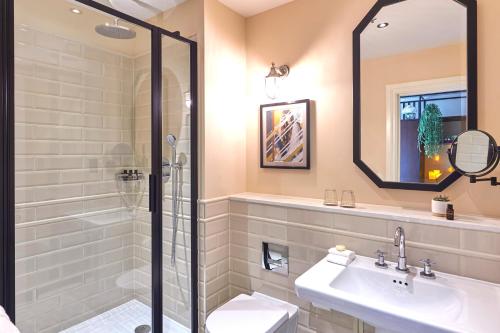 a bathroom with a sink, mirror, and bathtub at The Grand Hotel Birmingham in Birmingham