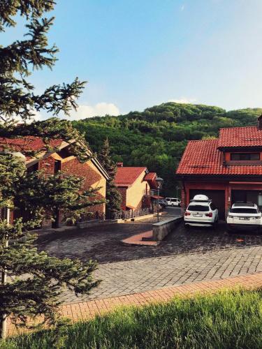 two cars parked in a parking lot next to a building at Teghenis Resort in Tsaghkadzor