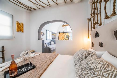 Un dormitorio con una cama y una bandeja con botellas. en Asera Suites only 300m from Kamari Beach en Kamari
