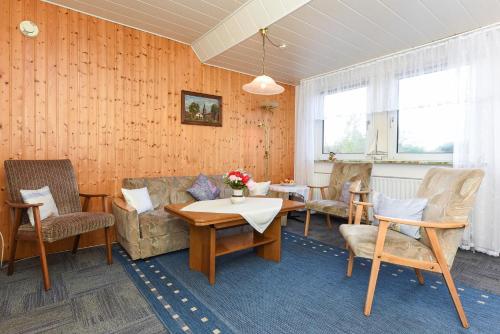 a living room with a couch and a table and chairs at Ferienwohnungen im Haus Beluga in Bensersiel
