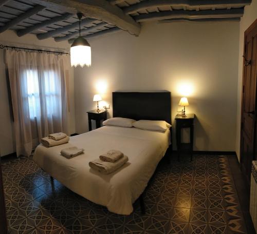 a bedroom with a large bed with towels on it at La Herrera lll in San Esteban de la Sierra