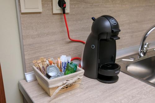 uma máquina de café sentada num balcão ao lado de um lavatório em Feel at Home em Sandanski