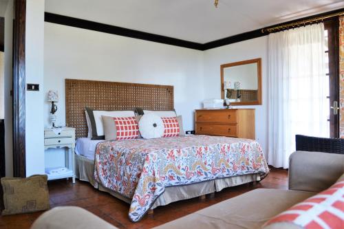 a bedroom with a large bed with red pillows at Byblos Luxury Villa in Prinos