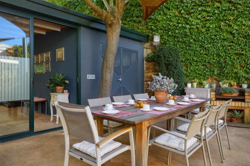 a wooden table and chairs on a patio at Casa Rural Can Coll in Garriguella