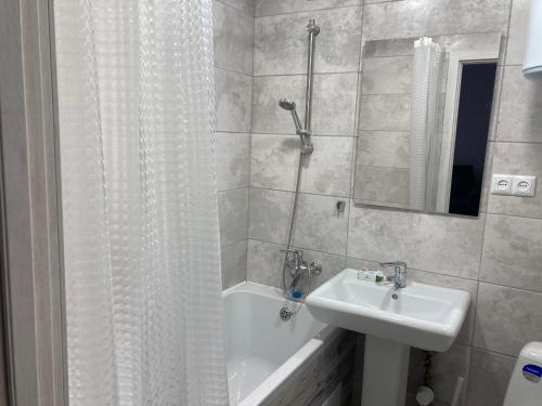 Un baño con lavabo, ducha y bañera. en White&Grey apartment, en Vínnytsia