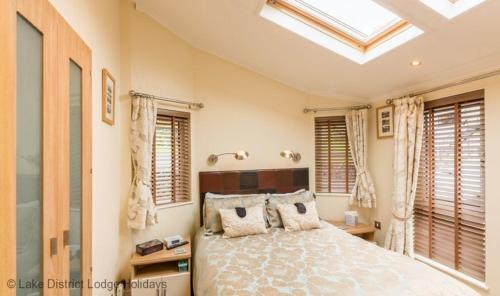 a bedroom with a bed and a skylight at Elder Lodge in Windermere