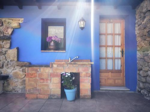 a blue room with a fireplace and a door at La casa de Manín in San Sebastián de Garabandal