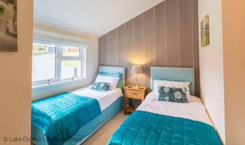 a bedroom with two beds and a window at Sheffield Pike Lodge in Windermere