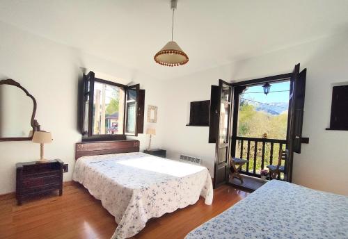 1 Schlafzimmer mit 2 Betten und einem Fenster in der Unterkunft La casa de Manín in San Sebastián de Garabandal