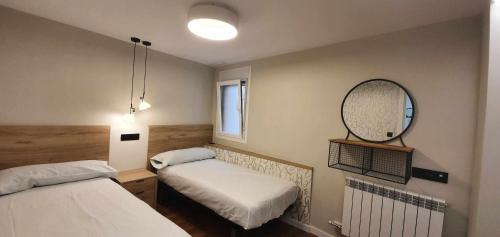 - une petite chambre avec 2 lits et un miroir dans l'établissement Apartamento EL PILAR Céntrico ascensor cocina WIFI en Zaragoza by lodom, à Saragosse