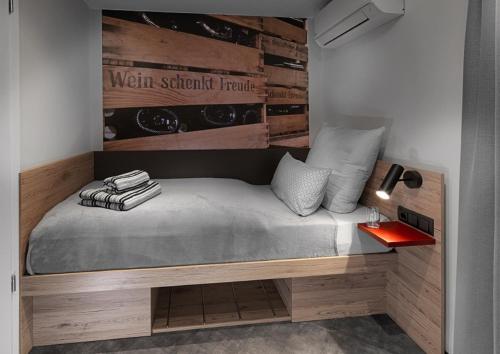 a bed in a room with a wall with wine bottles at WeinMotel Simon 1 a in Alzenau in Unterfranken
