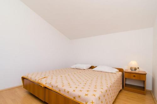 a bedroom with a bed with a nightstand and a bed sidx sidx sidx sidx at Apartments Sutvid in Drače