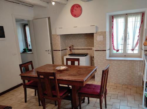 cocina con mesa de madera, sillas y reloj en Corte Clocego, en Verona