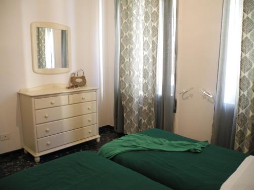 a bedroom with a bed and a dresser and a mirror at Aquarium by the Sea in Levanto