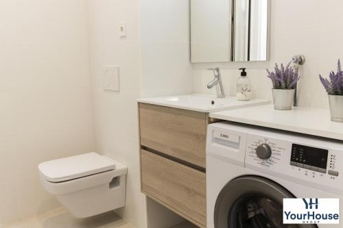 a bathroom with a washing machine and a sink at YourHouse Es Niu, apartment in Puerto de Sóller in Sóller