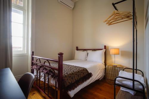 um quarto com uma cama e uma janela em Alojamento Duque D`Avila em Aveiro
