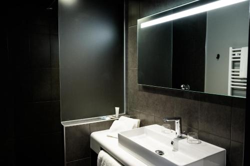 a bathroom with a white sink and a mirror at Best Western Plus Le Canard sur le Toit in Colomiers