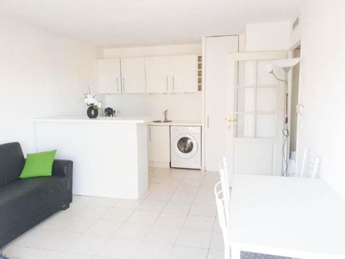 un salon avec un canapé noir et une cuisine dans l'établissement Résidence Les domes, Piscine, à Nice