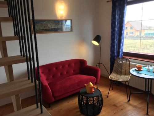 a living room with a red couch and a table at Tatraview House in Veľká Lomnica