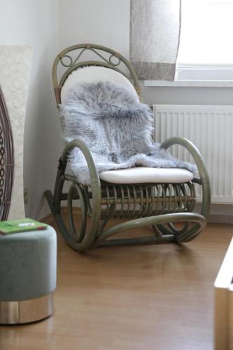 a wooden rocking chair with a blanket on it at Ferienhof Neukirchinger in Tiefenbach