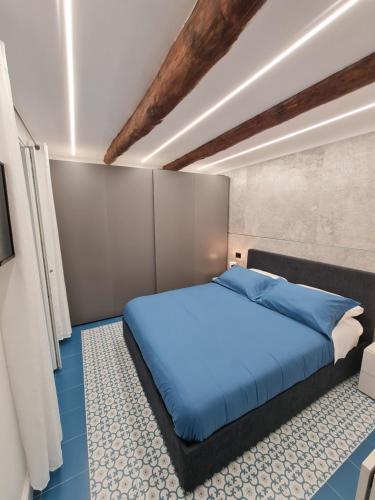 um quarto com uma cama azul num quarto em Chiaja Lux House em Nápoles