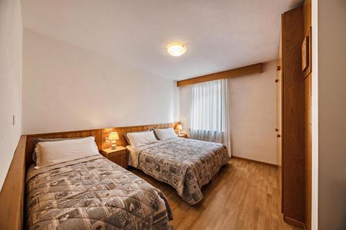 a hotel room with two beds and a window at Appartamento Primavera 2 in Moena