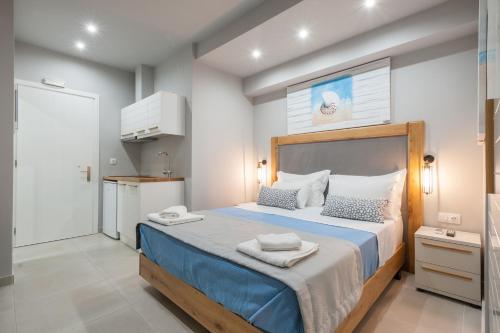 a bedroom with a large bed with towels on it at Armonia Rooms in Myrina