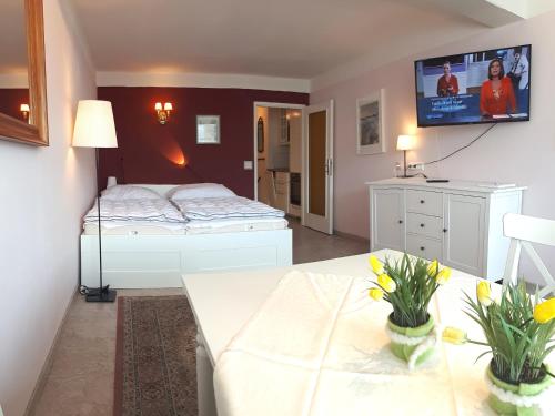 a bedroom with two beds and a tv on the wall at JOHANNES Seeblick Appartement im Haus Hänsel Gretel direkt am Ossiachersee in Stiegl