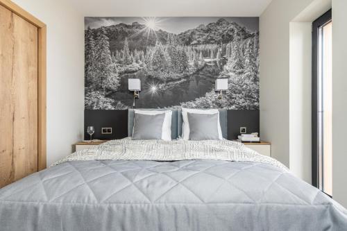 a bedroom with a bed with a large painting on the wall at Villa 16 Zakopane in Zakopane